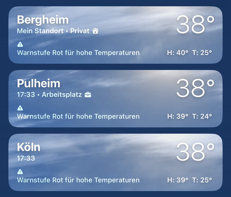 Screenshot der iPhone-Wetter-App mit drei Wetterkarten für Bergheim, Pulheim und Köln. Alle drei Orte zeigen um 17:33 Uhr eine Temperatur von 38 °C sowie eine rote Hitzewarnung („Warnstufe Rot für hohe Temperaturen“). Für Bergheim wird eine Höchsttemperatur von 40 °C und eine Tiefsttemperatur von 25 °C angezeigt, für Pulheim 39 °C bzw. 24 °C und für Köln 39 °C bzw. 25 °C. Die drei nahezu identischen Werte verdeutlichen die extreme Hitzewelle in der Region.